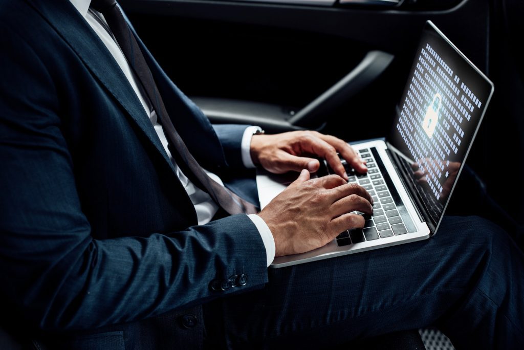 partial view of african american businessman using laptop with gdpr illustration in car